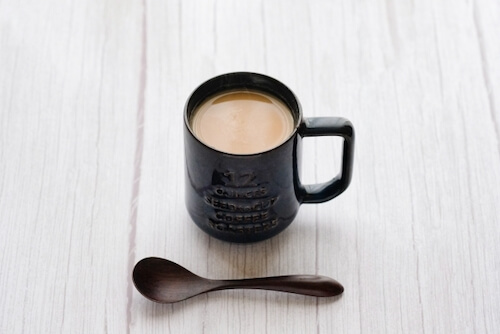 黒いマグカップに入ったコーヒーラテの写真